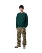 Hombre con sudadera Carhartt WIP American Script Sweatshirt verde Dark Fir corte holgado 