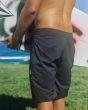 Hombre con Tabla de surf y Bañador Volcom Lido Solid Mod 20' Negro posterior