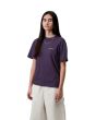 Mujer con camiseta Carhartt WIP Script Embroidery morada con logo bordado en beige 
