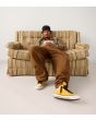 Hombre sentado con Zapatillas Converse Chuck Taylor Throwback High Top amarillas Unisex