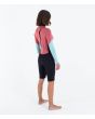 Mujer con neopreno corto Hurley Air 2mm MId Shorty Springsuit de manga  larga color Spiced Coral posterior derecha