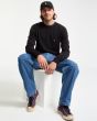 Hombre sentado con Jersey Volcom Uperstand Sweater Negro