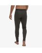 Hombre con mallas interiores Patagonia Men's Capilene Midweight Bottoms en negro posterior