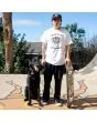 Hombre con perro y monopatín con la Camiseta Independent x Motörhead Warpig blanca