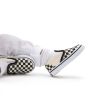 Bebé con Zapatillas Vans Slip-On blancas y negras con estampado Checkerboard detalle