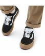 Hombre con Zapatillas de Skateboard Vans Old Skool negras con suela de goma y banda lateral blanca 