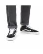 Zapatillas Vans de caña media Mid Skool negras y banda lateral blanca Unisex puestas